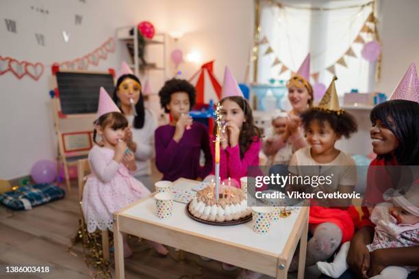 bambina che ha una festa di compleanno con gli amici - candeline di compleanno foto e immagini stock