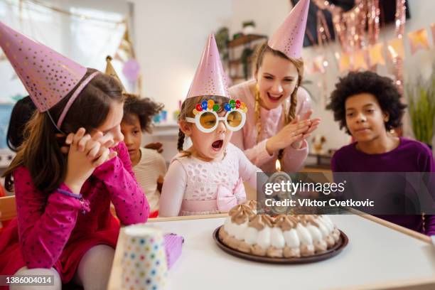 bambina che soffia la sua candela di compleanno - kids birthday party foto e immagini stock