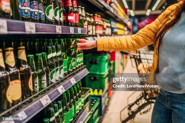 customer buying beer in liquor store - bierfles stockfoto's en -beelden