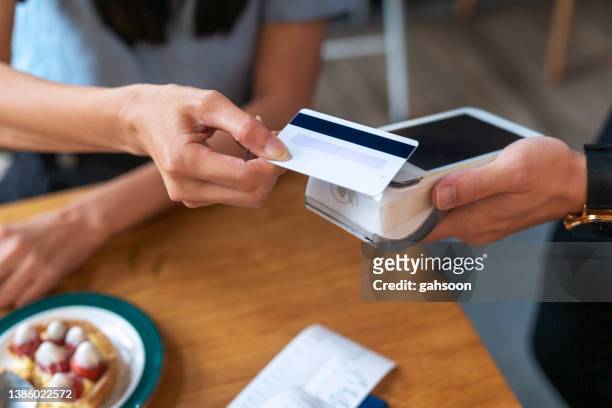 nfc contactless payment by credit card and pos terminal - paid stockfoto's en -beelden