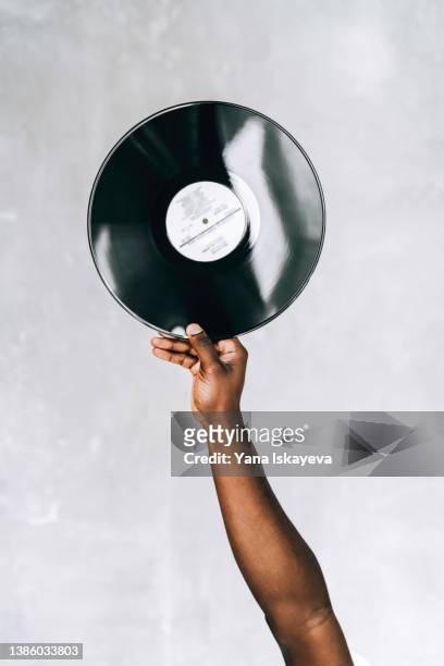 hand holding a black plastic vinyl disk - black dj stock pictures, royalty-free photos & images