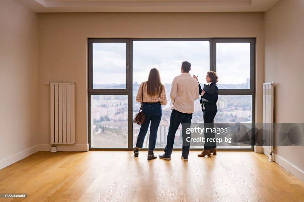 Female real estate agent showing house to young couple