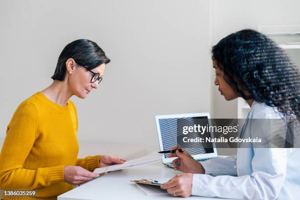 african-american doctor consulting female patient, giving instructions and recommendations - medical research foto e immagini stock