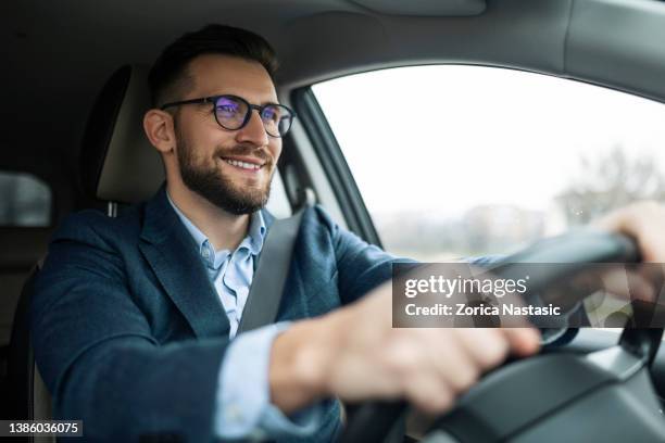 homme d’affaires souriant conduisant sa voiture - business man modern city photos et images de collection