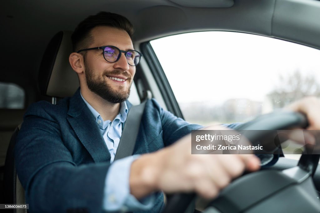 Empresário sorridente dirigindo seu carro