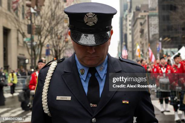 Member of the FDNY bows his head during a moment of silence in honor of the fallen NYPD and FDNY officers on September 11 in the St. Patrick’s Day...