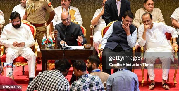 Leader Ajit Pawar interacts with Dy CM Devendra Fadnavis while CM Eknath Shinde was constantly checking his mobile, while oath taking ceremony at Raj...