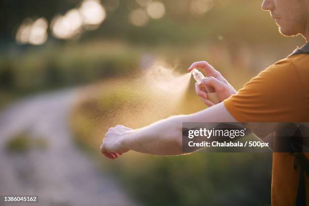 man applying insect repellent on his hand - mosquito bite stock-fotos und bilder