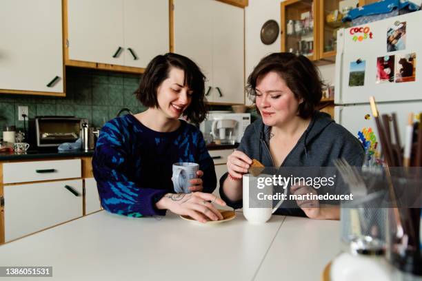 lesbian couple enjoying simple pleasures at home, drinking good coffee. - millennial generation couple stock pictures, royalty-free photos & images