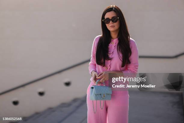 Leo Eberlin seen wearing brown sunglasses from Bottega Veneta, a pink cashmere sweater from Allude, matching pink cozy pants, a pale blue leather bag...