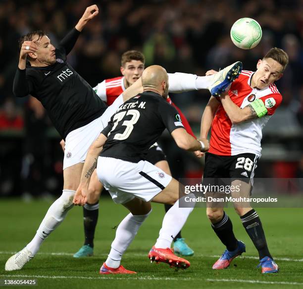 Jens Toornstra of Feyenoord is challenged by Sinisa Sanicanin of FK Partizan during the UEFA Conference League Round of 16 Leg Two match between...