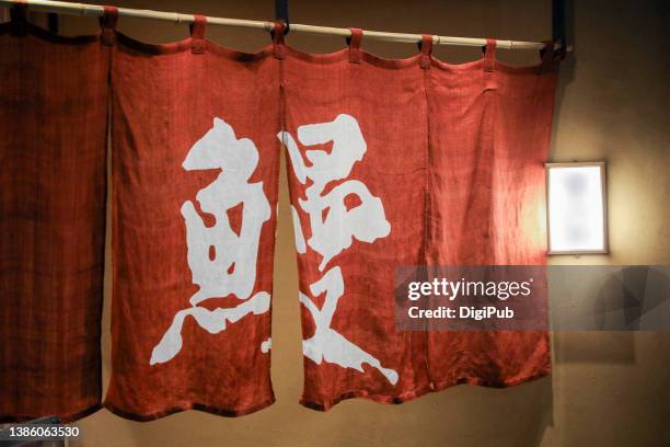 unagi eel in kanji on noren curtain at the entrance of a japanese ryotei restaurant in tokyo - noren stock pictures, royalty-free photos & images