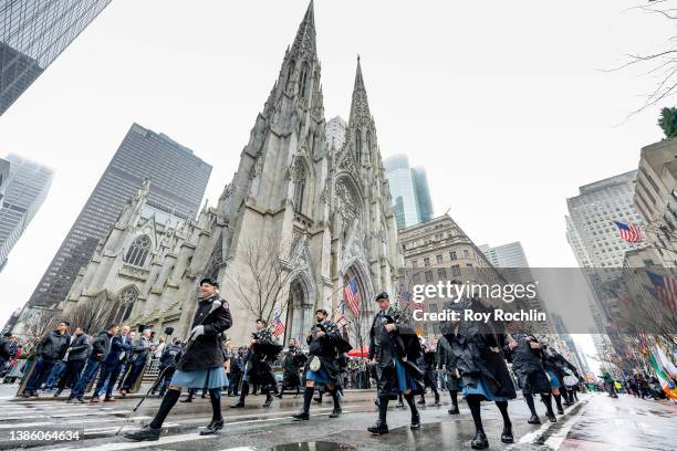 Police officers playing bagpipes in traditional dress march across St. Patrick's Cathedral during the 2022 NYC St. Patrick's Day Parade on March 17,...