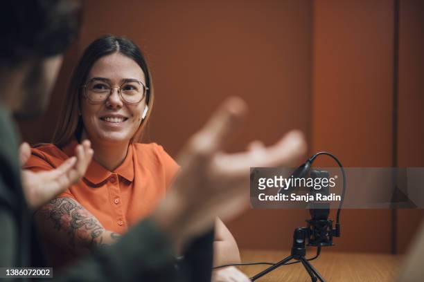 attraktive tätowierte unternehmerin wird in einer business-podcast-episode interviewt - woman interview stock-fotos und bilder