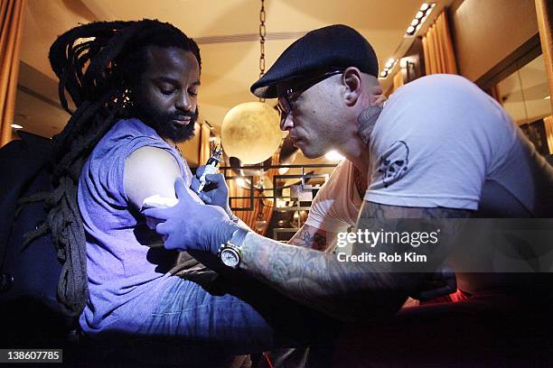 Ami James tattoos John Forte at The Ami James Ink Tattoo Pop-Up Shop at the Empire Hotel on February 9, 2012 in New York City.