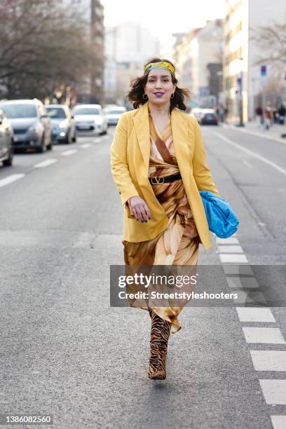 Influencer Claudia Vogel wearing a yellow blazer by Karen von Simonsen, a beige wrap dress by Lemanja, a black belt with gold buckle by Valentino,...