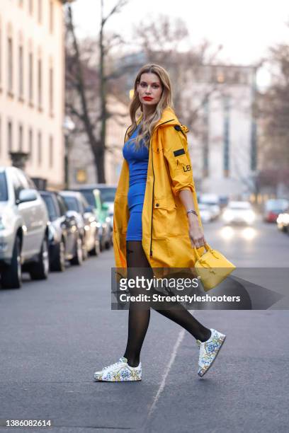Actress and model Rebecca Kunikowski wearing a yellow parka jacket by Left Right, jewelry by Left Right, sneaker by Dolce & Gabbana, black "u2018make...