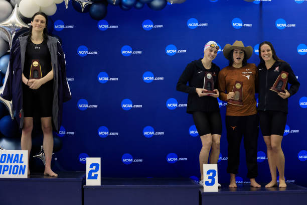 Transgender woman Lia Thomas of the University of Pennsylvania stands on the podium after winning the 500-yard freestyle as other medalists Emma...