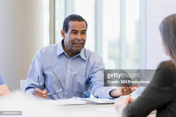 serious man gestures and asks unrecognizable professional woman some questions - lawyers serious stock pictures, royalty-free photos & images