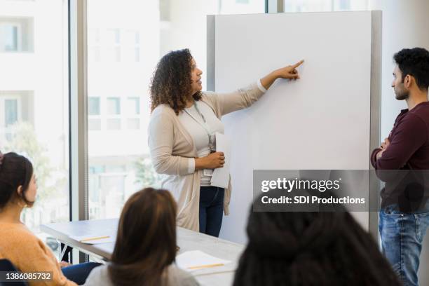college students gather around as teacher lectures - local politics stock pictures, royalty-free photos & images