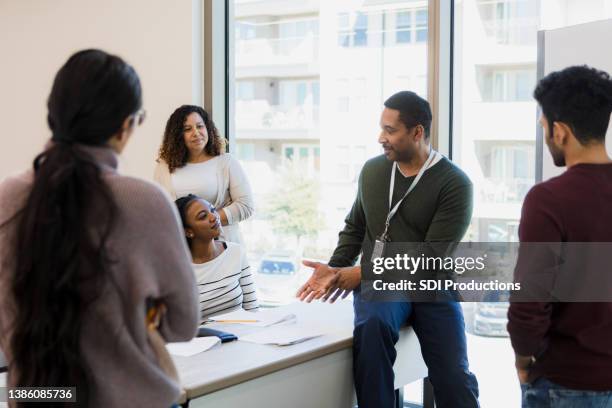 in a relaxed class session, mature professor interacts with students - local politics stockfoto's en -beelden