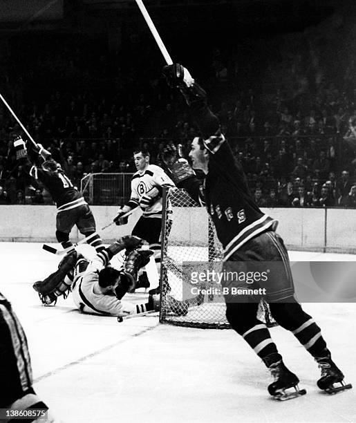 Andy Bathgate and Vic Hadfield of the New York Rangers celebrate their goal as Ed Westfall and goalie Eddie Johnston of the Boston Bruins look...