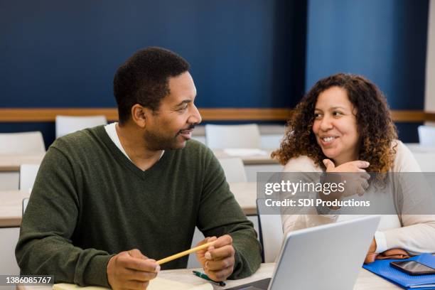 couple smiles and chats before evening class - inclusive classroom stock pictures, royalty-free photos & images