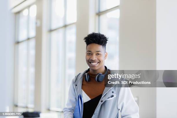 teenage boy with big smile poses for photo in library - guy with afro stock pictures, royalty-free photos & images