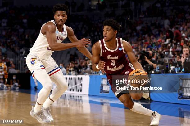 Henry of the Texas Southern Tigers drives against Ochai Agbaji of the Kansas Jayhawks during the first half in the first round of the 2022 NCAA Men's...