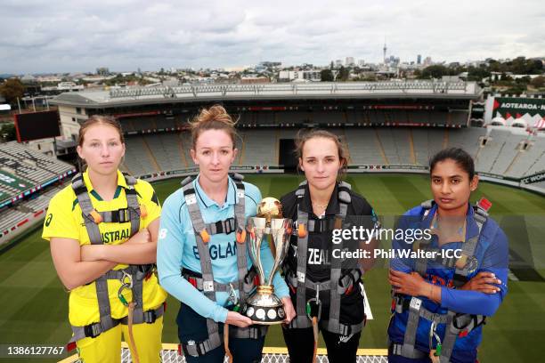 Darcie Brown of Australia, Kate Cross of England, Amelia Kerr of New Zealand and Mithali Raj of India pose on the roof of Eden Park during a 2022 ICC...