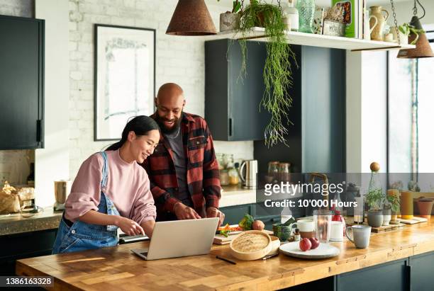 multiracial couple online shopping - cooking at home stock pictures, royalty-free photos & images