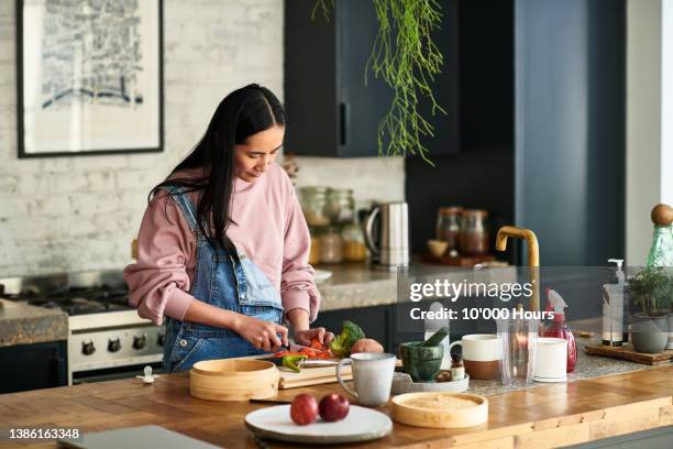 chinese woman prepares vegetable on kitchen worktop - en cuisine photos et images de collection