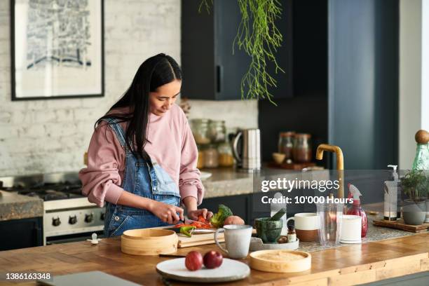 chinese woman prepares vegetable on kitchen worktop - cookery foto e immagini stock