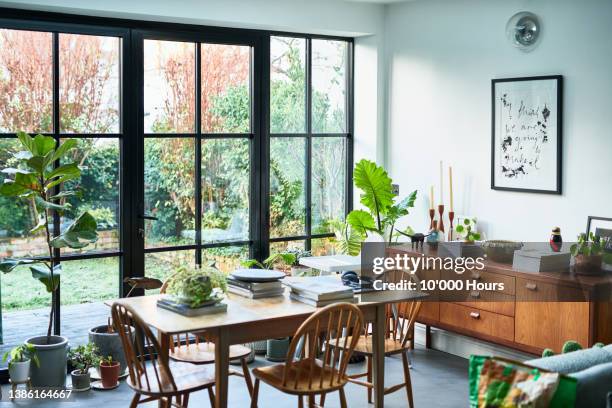 modern lounge with dining table by large window set up as home office - salle à manger photos et images de collection