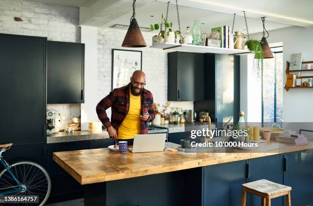 cheerful black freelancer in kitchen on video call, smiling - hipster in a kitchen stock-fotos und bilder