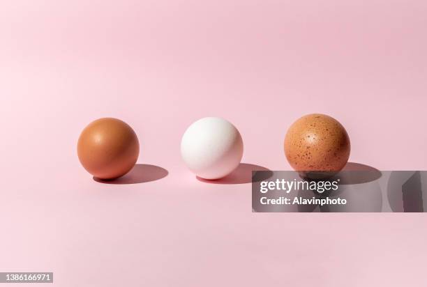 colored eggs with pink background concept of racial-ethnic and sexual diversity - art food stock pictures, royalty-free photos & images