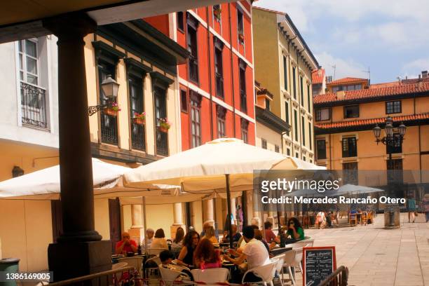 sidewalk cafes and multicolored traditional facades, rows of windowsin old town square. oviedo, asturias, spain. - oviedo stock pictures, royalty-free photos & images
