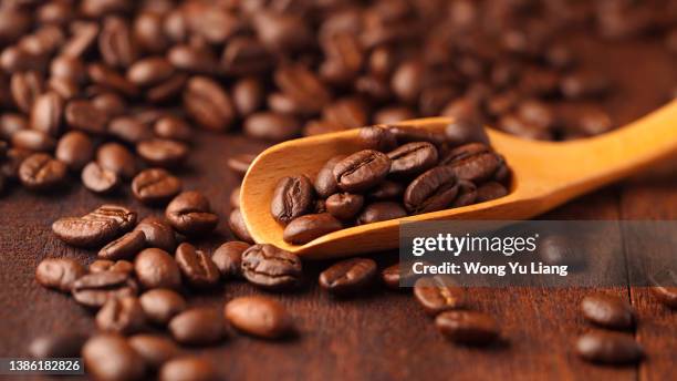 coffee bean on wooden spoon , with wood background - cafeteria fotografías e imágenes de stock