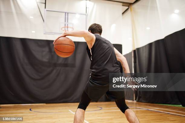 basketball player dribbling ball during training - basketball uniform stock-fotos und bilder