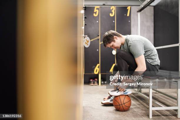 basketball player tying laces on sneakers - sports equipment locker stock pictures, royalty-free photos & images