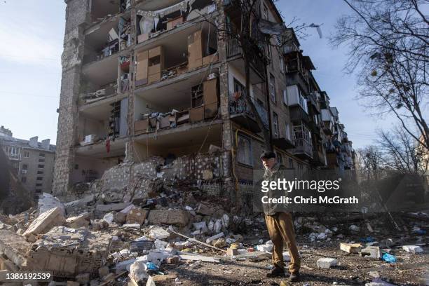 Man stands amid debris in front of a residential apartment complex that was heavily damaged by a Russian attack on March 18, 2022 in Kyiv, Ukraine....