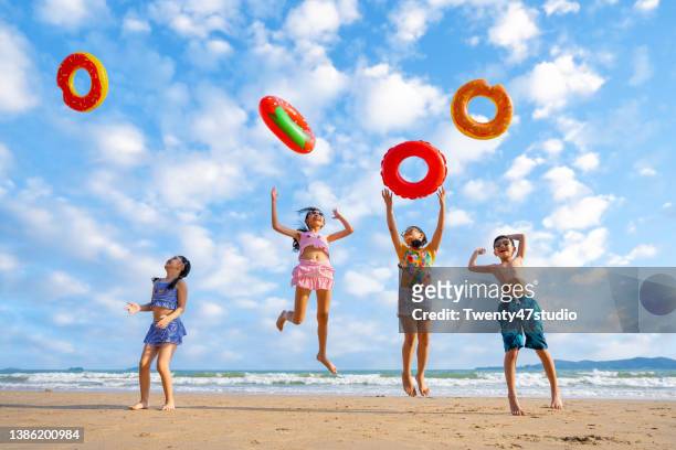 playful children playing on the beach - preteen swimwear bildbanksfoton och bilder