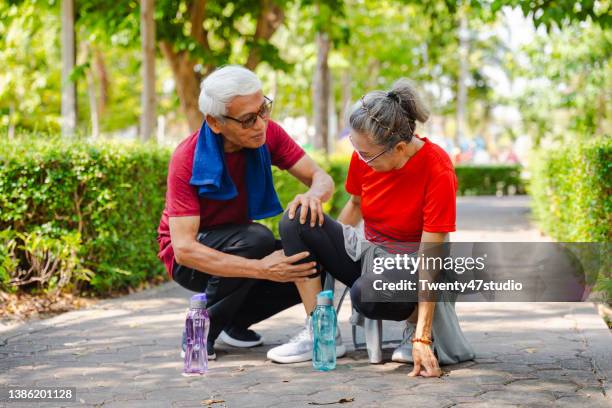 senior couple injured the knee after walking the park - injured knee stock pictures, royalty-free photos & images