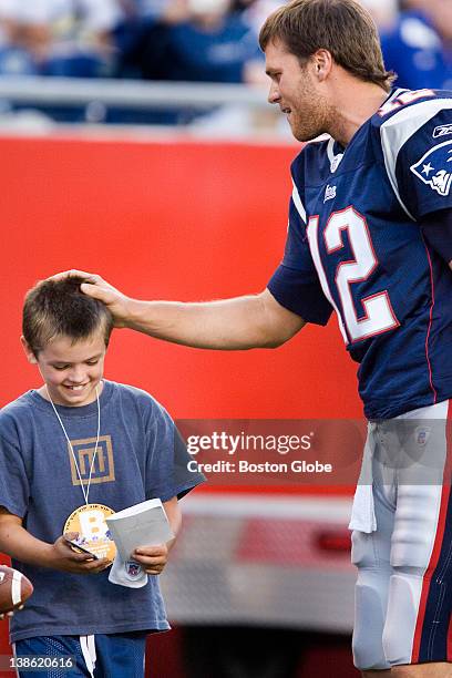 Jackson Damon nephew of actor Matt Damon, gets a pat on the head, an autograph and a wristband from patriots quarterback Tom Brady before the...