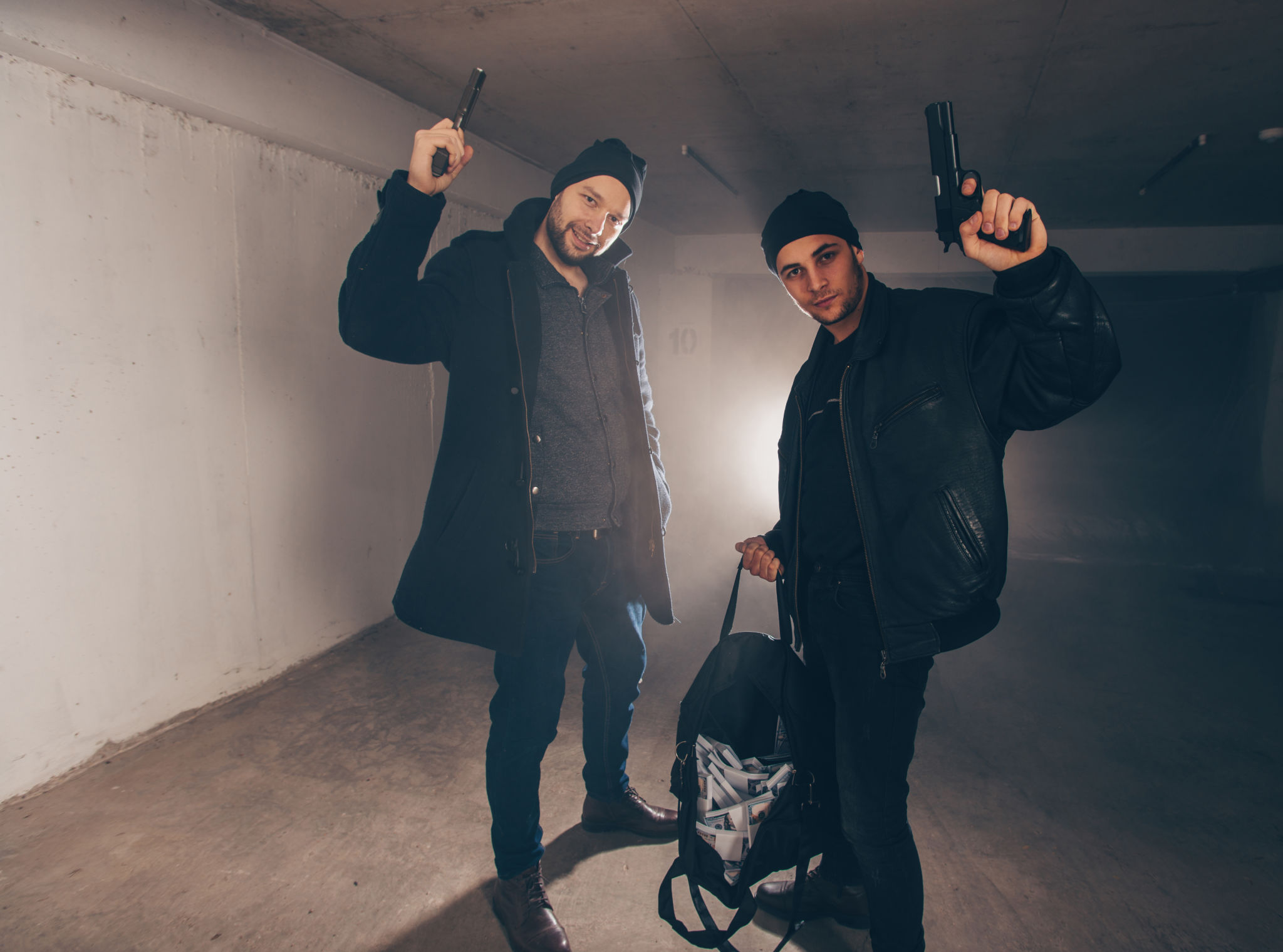 Burglars with stolen money standing in a garage Burglars with stolen money standing in a garage