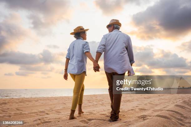 lovely senior couple on the beach - senior romance stock pictures, royalty-free photos & images
