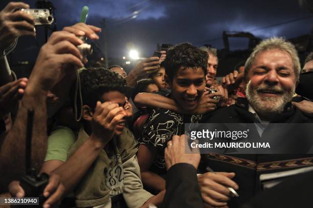 Brazil's President Luiz Inacio Lula da Silva is greeted by residents during a ceremony to deliver 224 new houses as part of his Accelerated Growth...