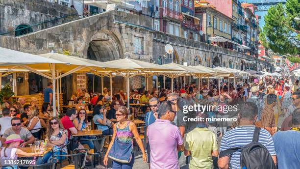 street cafes and crowded people in ribeira, porto, portugal - ribeira porto stock pictures, royalty-free photos & images