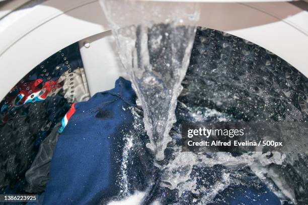 high angle view of washing machine in mid cycle with running water - washing machine with bubbles stock pictures, royalty-free photos & images