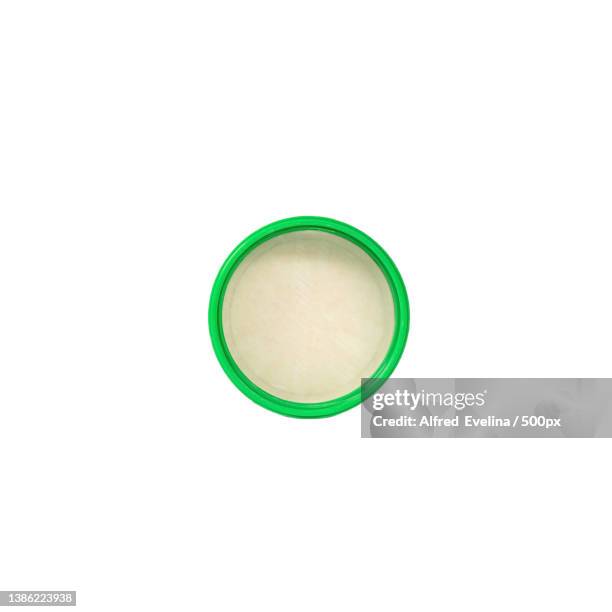 green plastic bottle cap flat lay on white background directly above view - flat cap stock-fotos und bilder